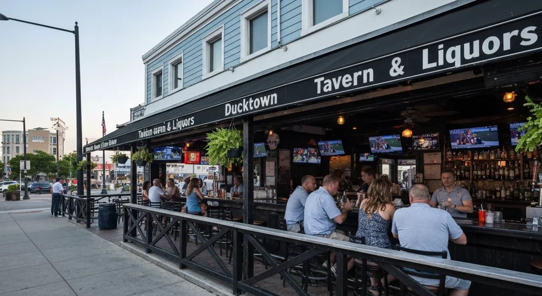 el bar al aire libre de Ducktown Tavern & Liquors en Georgia Avenue en una tarde de verano, con vecinos habituales y pantallas deportivas visibles dentro